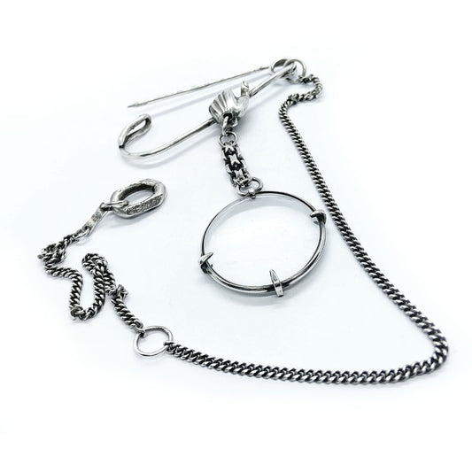 Magnifying glass brooch.