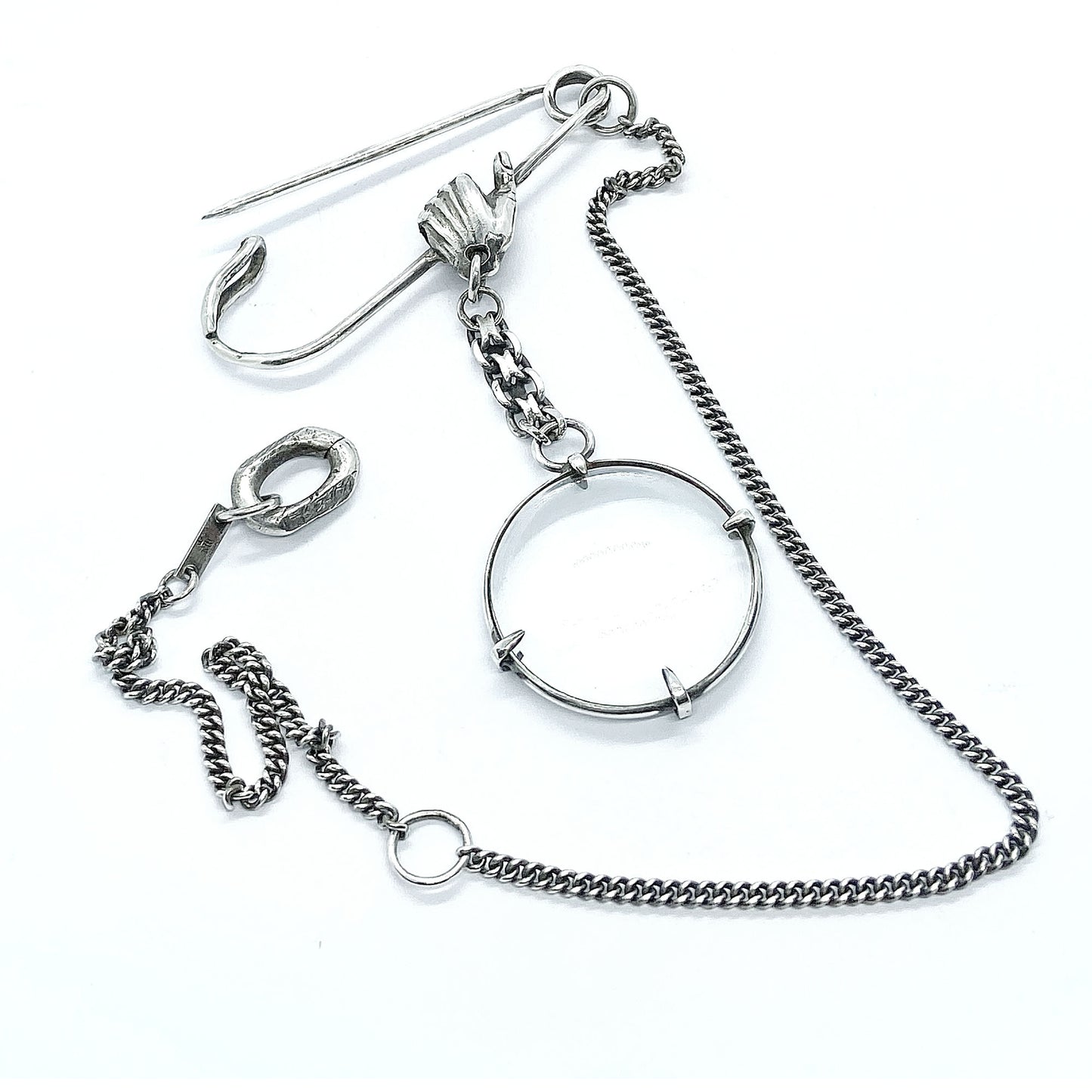 Magnifying glass brooch.
